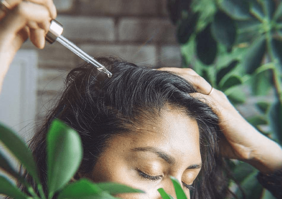 Woman adding serum to her hair